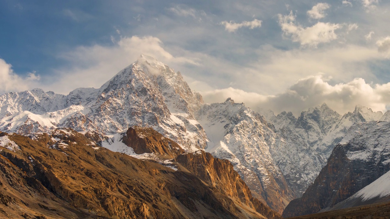 在巴基斯坦罕萨河谷地区的帕苏山谷，喀喇昆仑山脉雪山壮丽景色的延时移动云日出场景视频素材