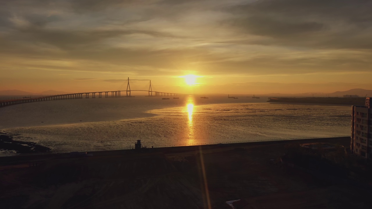 在韩国仁川的松岛区/延寿区，仁川大桥周围的日落海景视频素材