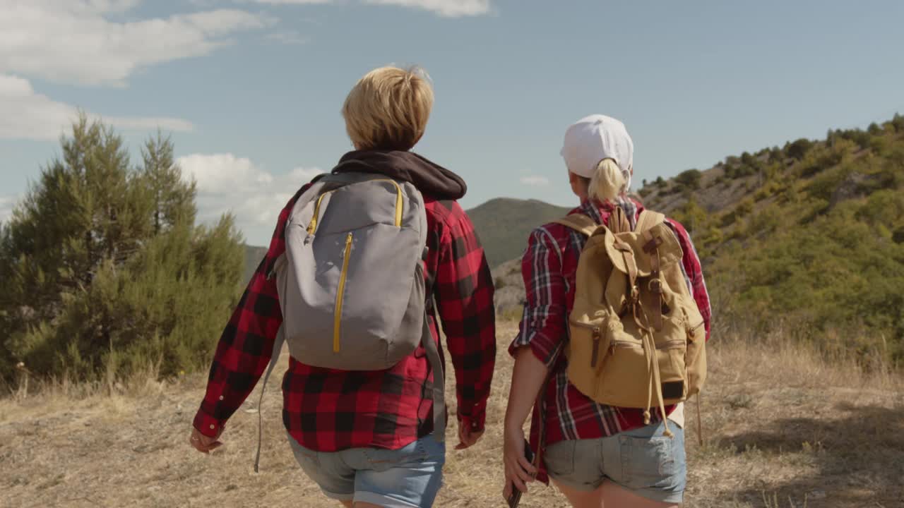 女性朋友在旅行中以美丽的山景为背景，用智能手机自拍视频素材