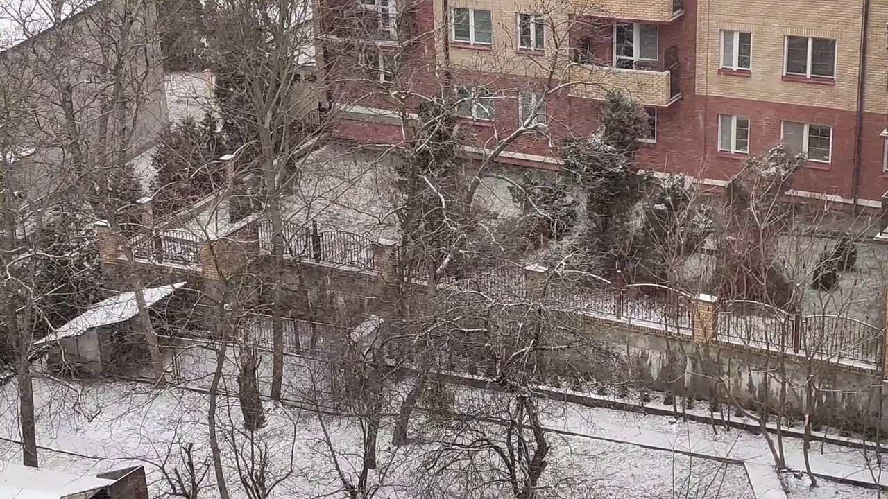 公寓大楼庭院背景上的降雪视频素材