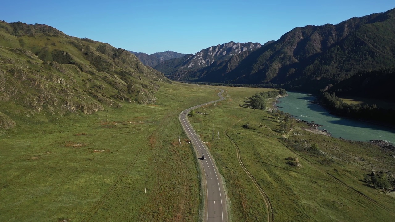 白色SUV面包车行驶在柏油路上，夏日山间风光与江边游之旅鸟瞰视频素材