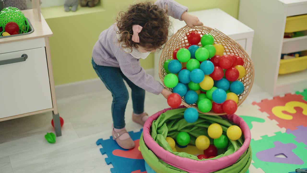 可爱的西班牙女孩站在幼儿园玩球视频素材