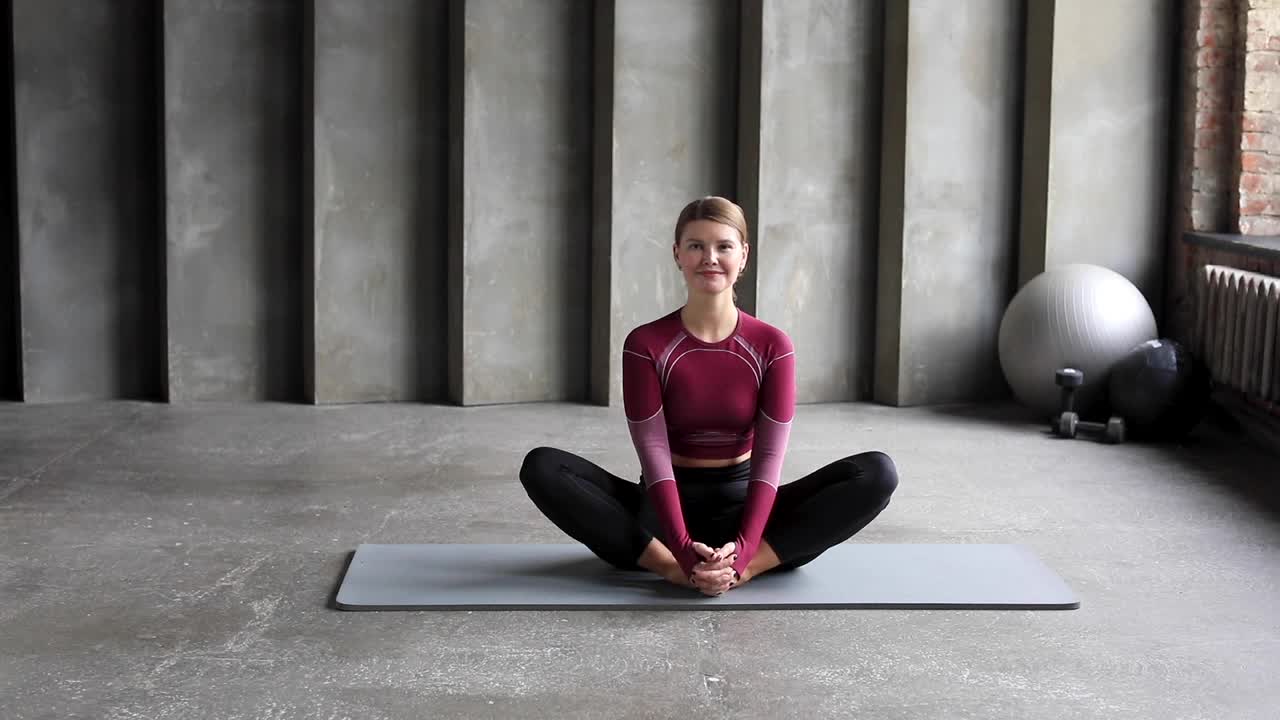 一个穿着运动服的女人在垫子上练习瑜伽，普拉提。拉伸，瑜伽课。视频素材
