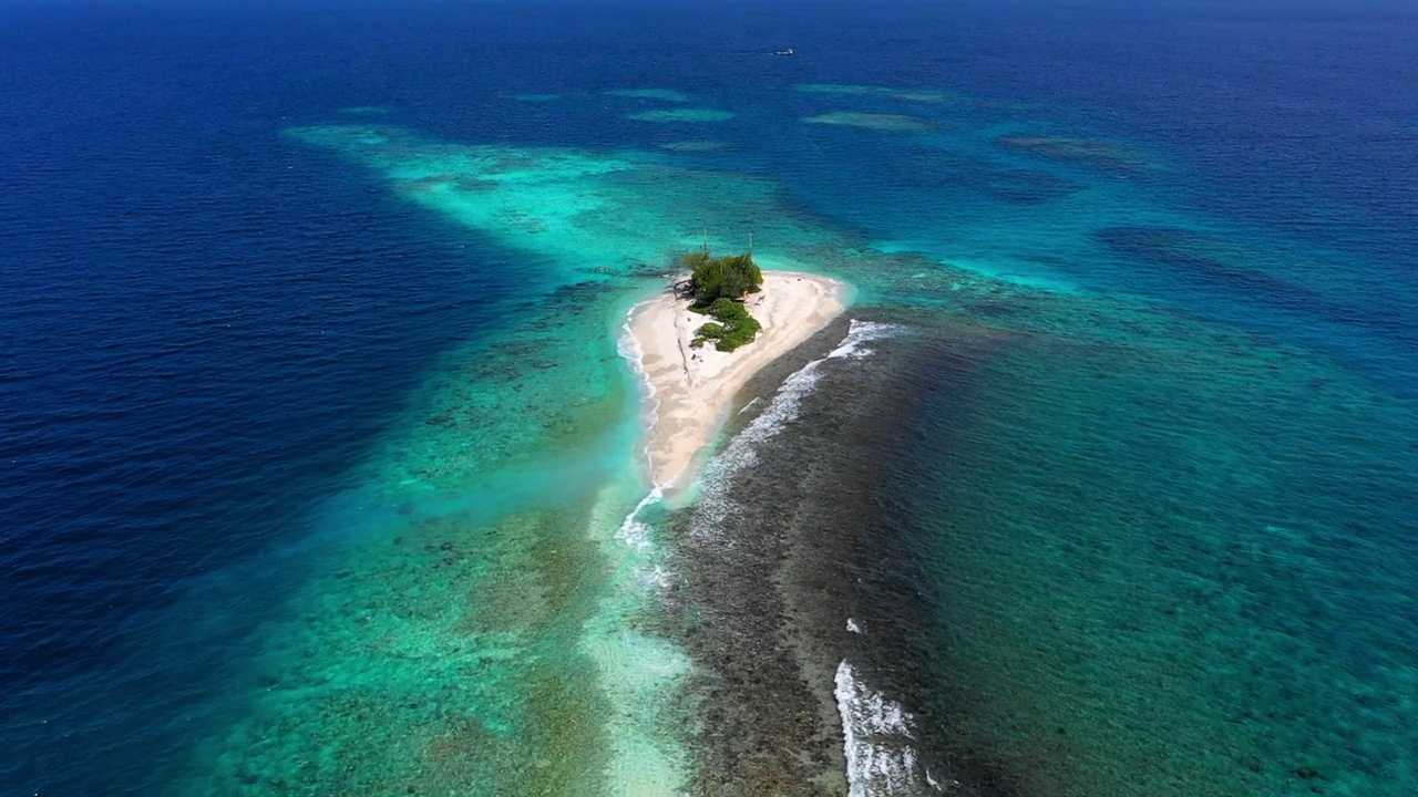 海浪溅在海滩岛上的航拍风景，无人机在阳光灿烂的日子里飞在海面上-马尔代夫的thulushoo视频素材