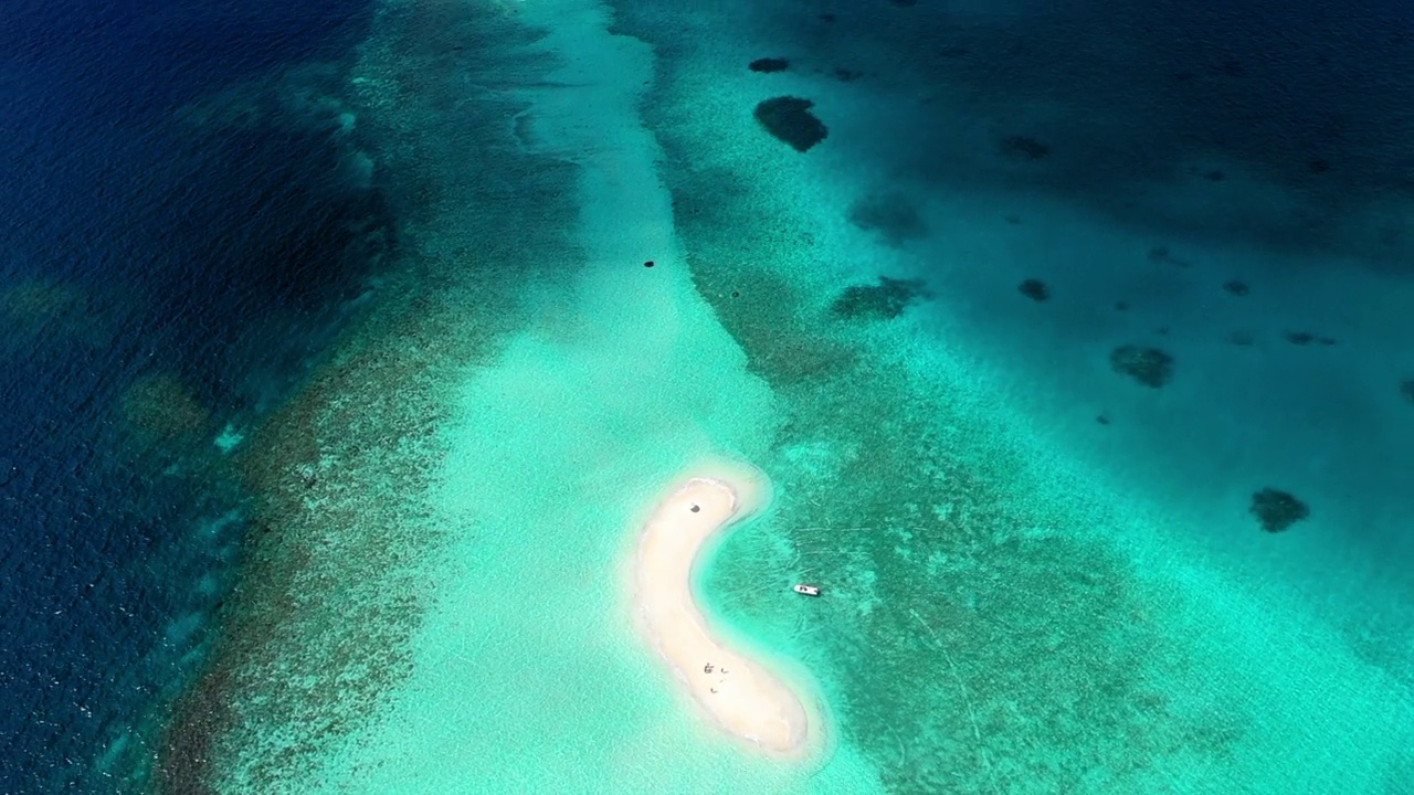 空中倾斜拍摄的游客在海边的海滩上，无人机在阳光明媚的日子里向后飞行——马尔代夫的thulushoo视频素材