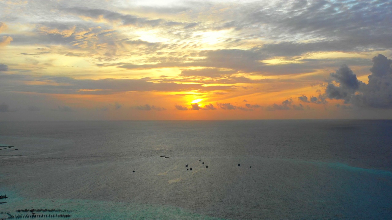 航拍的风景船停泊在宁静的海景，无人机在日落时飞越海浪- thulushoo，马尔代夫视频素材