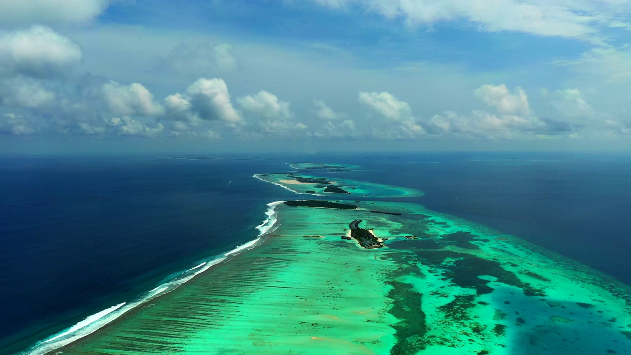 阳光灿烂的日子里云下宁静海景的空中前进风景-马尔代夫的thulushoo视频素材