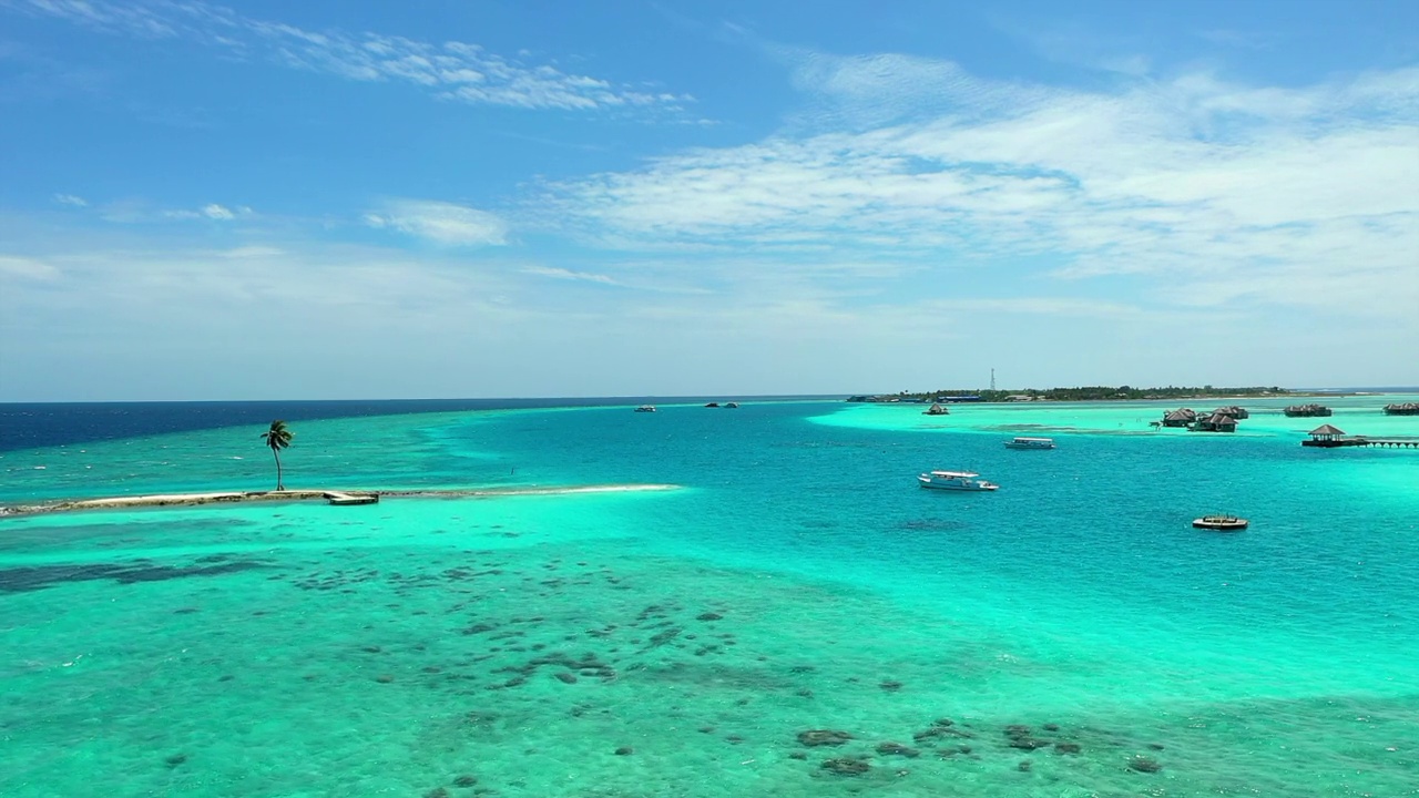 航拍在海滩和旅游胜地中的航海船只，无人机在蓝绿色波浪海上向前飞行-马尔代夫的thulushoo视频素材