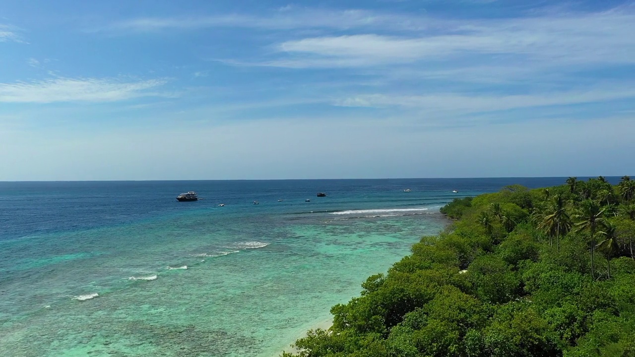 海上航海船只的航拍美景，无人机在阳光灿烂的日子里飞越岛上的植物-马尔代夫的thulushoo视频素材