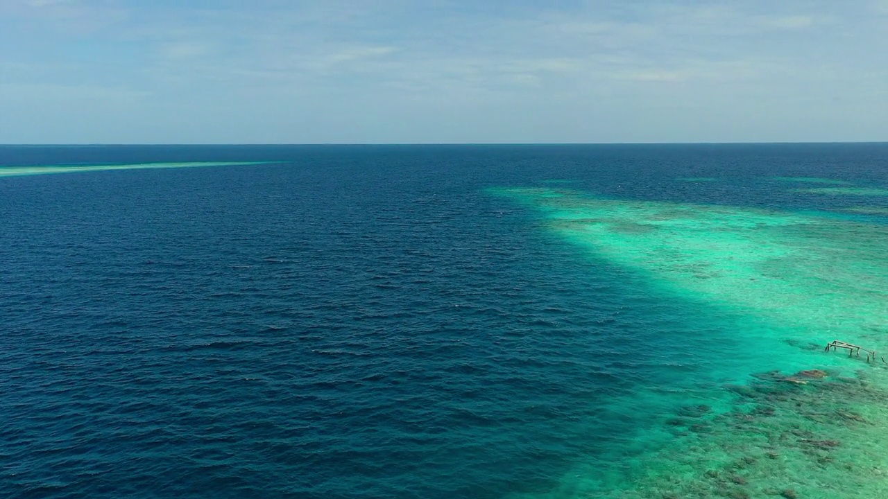 鸟瞰蓝绿色和蓝色的海景，无人机在阳光灿烂的日子里向前飞行-马尔代夫的thulushoo视频素材