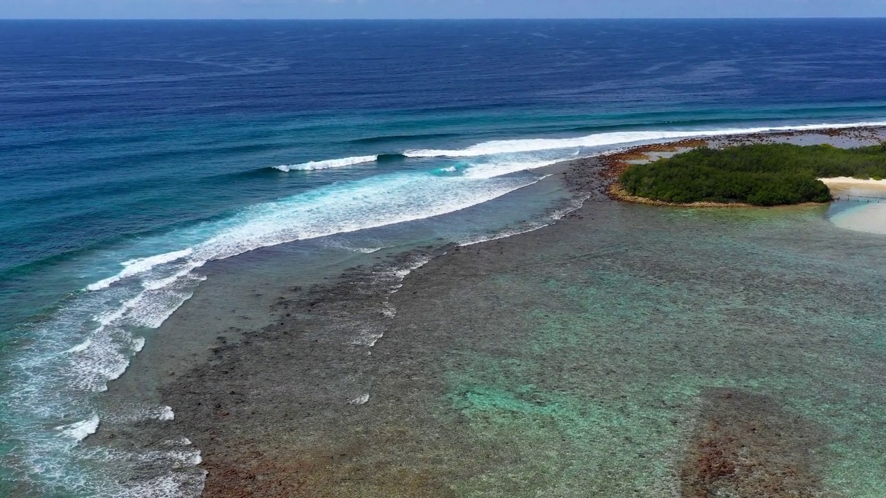 阳光明媚的日子里，海浪在多云的天空中飞溅的空中风景拍摄-马尔代夫的thulushoo视频素材