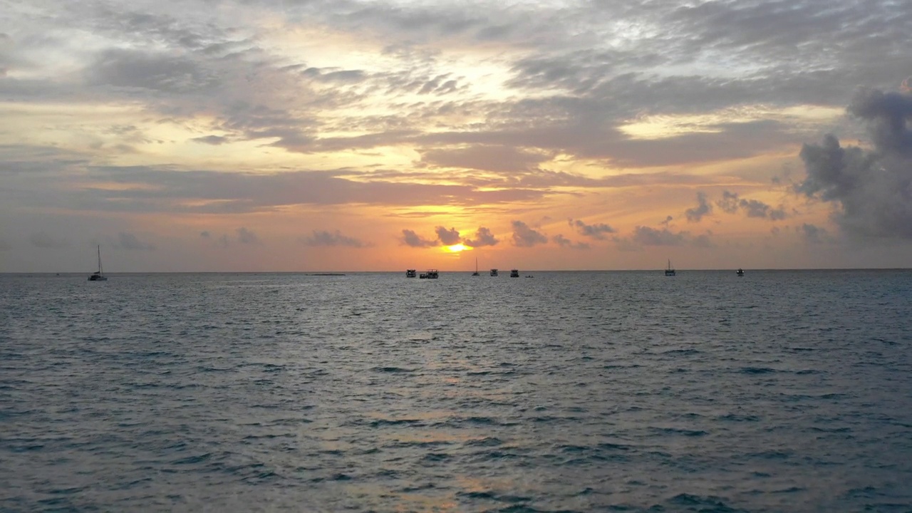 空中倾斜的航海船只的风景拍摄，无人机在日落期间飞在海上的波浪上- thulushoo，马尔代夫视频素材