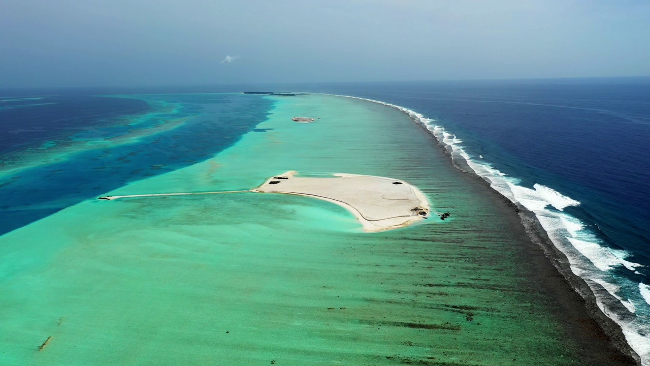 空中拍摄的蓝色和蓝绿色大海中的空海滩岛，无人机在阳光灿烂的日子里向前飞行——马尔代夫的thulushoo视频素材