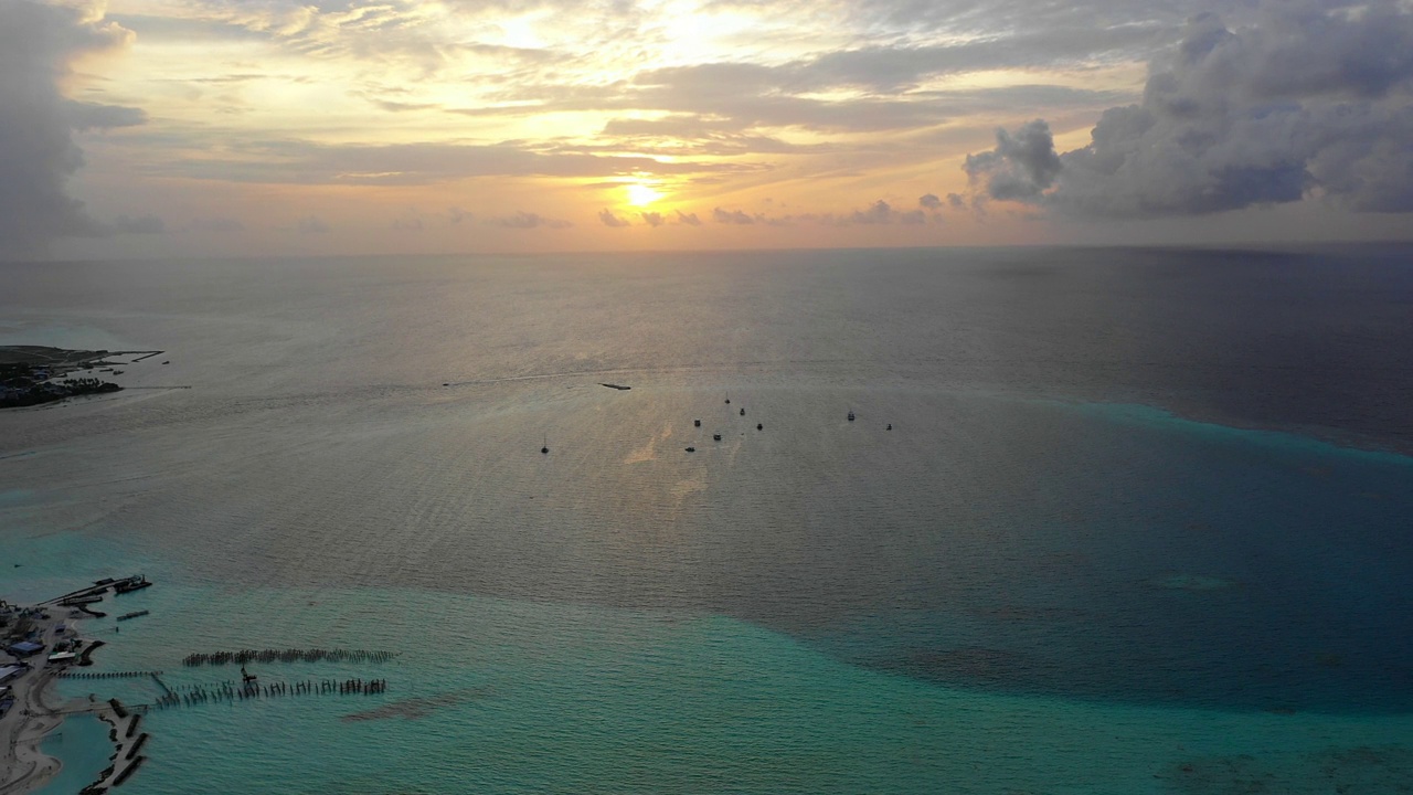 海上船只的空中平移风景拍摄，日落时无人机在云层下向后飞行-马尔代夫thulushoo视频素材