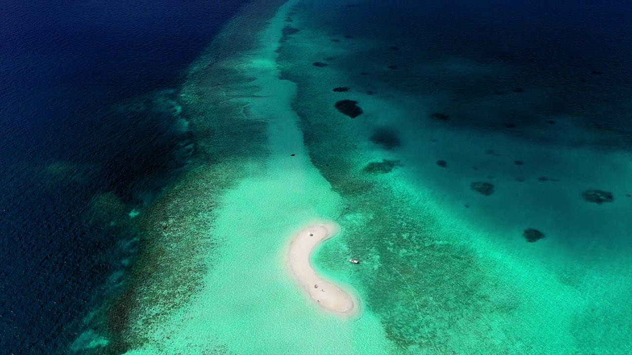 空中倾斜拍摄的游客在绿松石海中的海滩岛，无人机在阳光灿烂的日子里向后飞行——马尔代夫的thulushoo视频素材