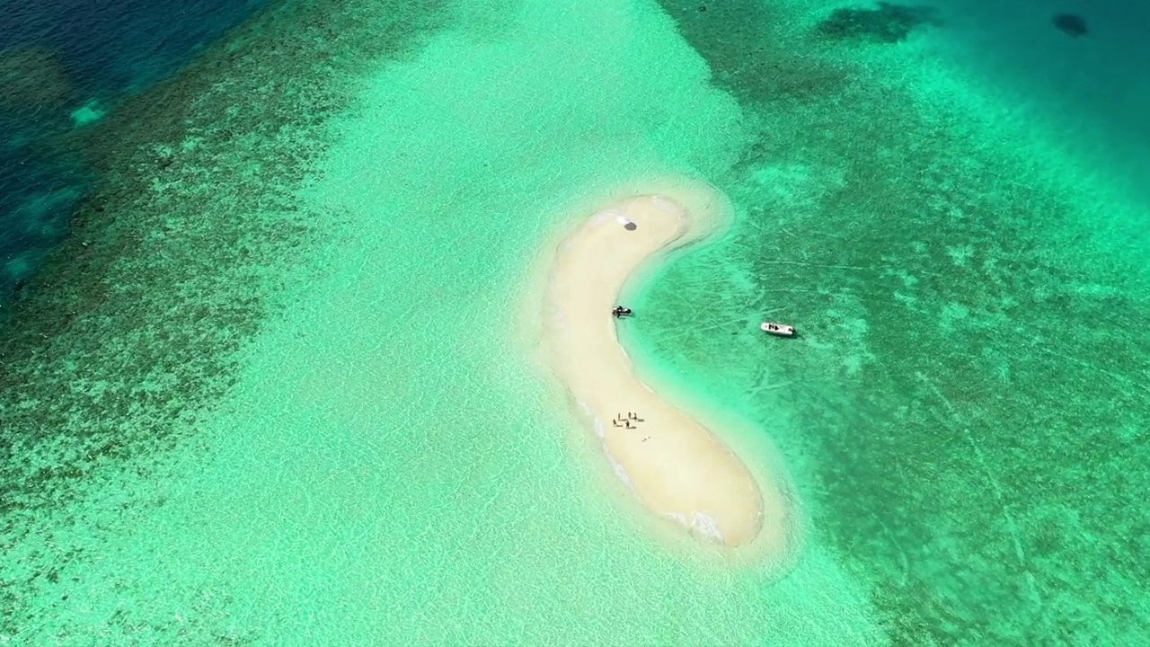 空中拍摄的人们在海滩岛度假，无人机在阳光明媚的日子里在蓝绿色的海洋上下降-马尔代夫的thulushoo视频素材