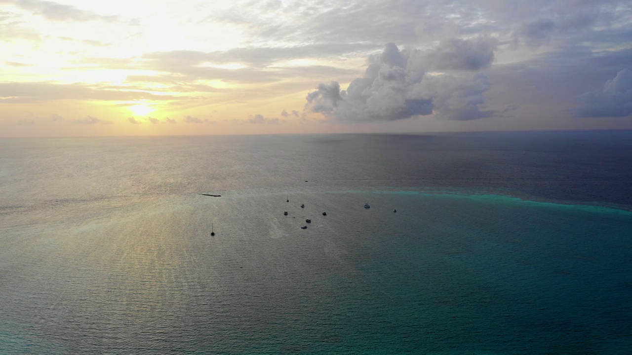 海上船只在日落时云层下的宁静景色的空中平移镜头-马尔代夫的thulushoo视频素材