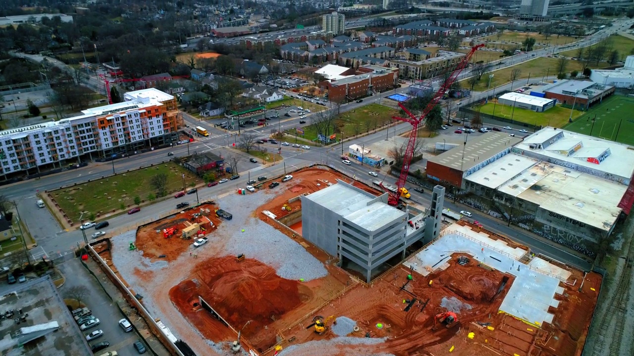 空中倾斜的建筑工地由汽车在天空下的城市道路上移动的镜头-亚特兰大，佐治亚州视频素材