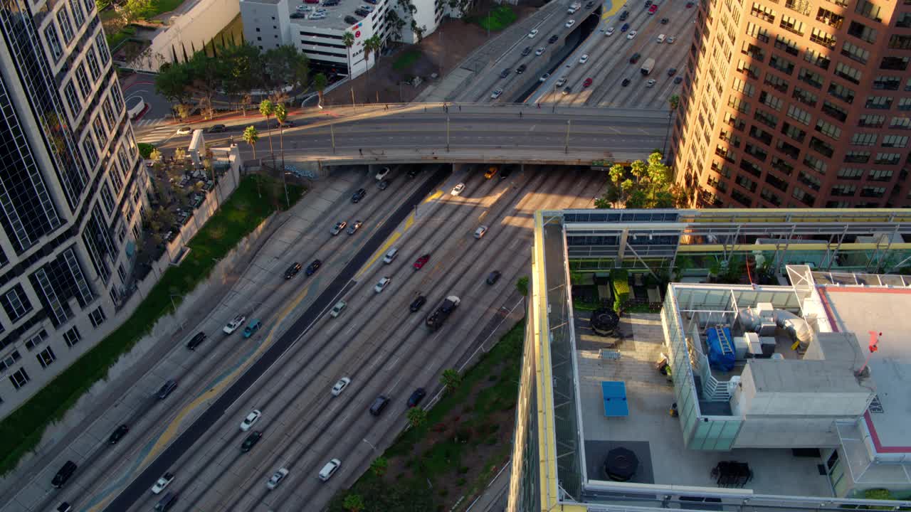 航拍汽车在道路上移动，无人机在日落时飞越现代城市-加利福尼亚州洛杉矶视频素材