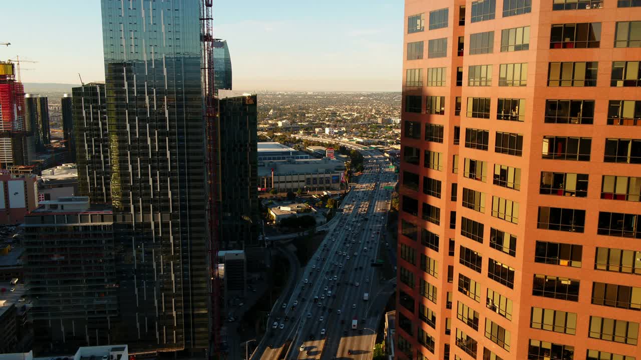 空中平移拍摄的汽车在日落期间在住宅城市与天空的道路上移动-洛杉矶，加利福尼亚视频素材