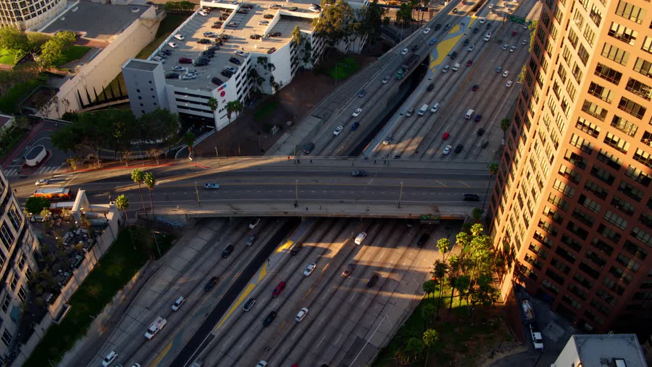 航拍车辆在道路上移动，无人机在日落时飞越现代城市-加利福尼亚州洛杉矶视频素材