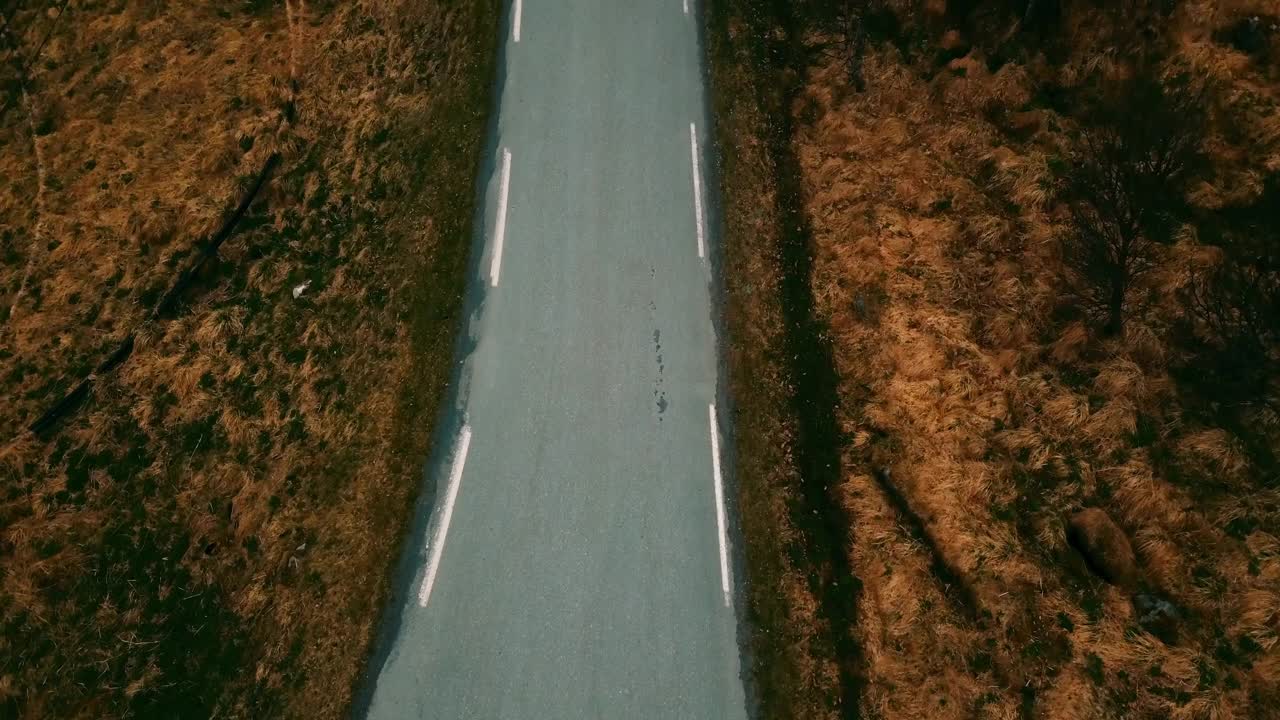 倾斜镜头的道路在村庄的房子在雪山对多云的天空-特罗姆瑟，挪威视频素材