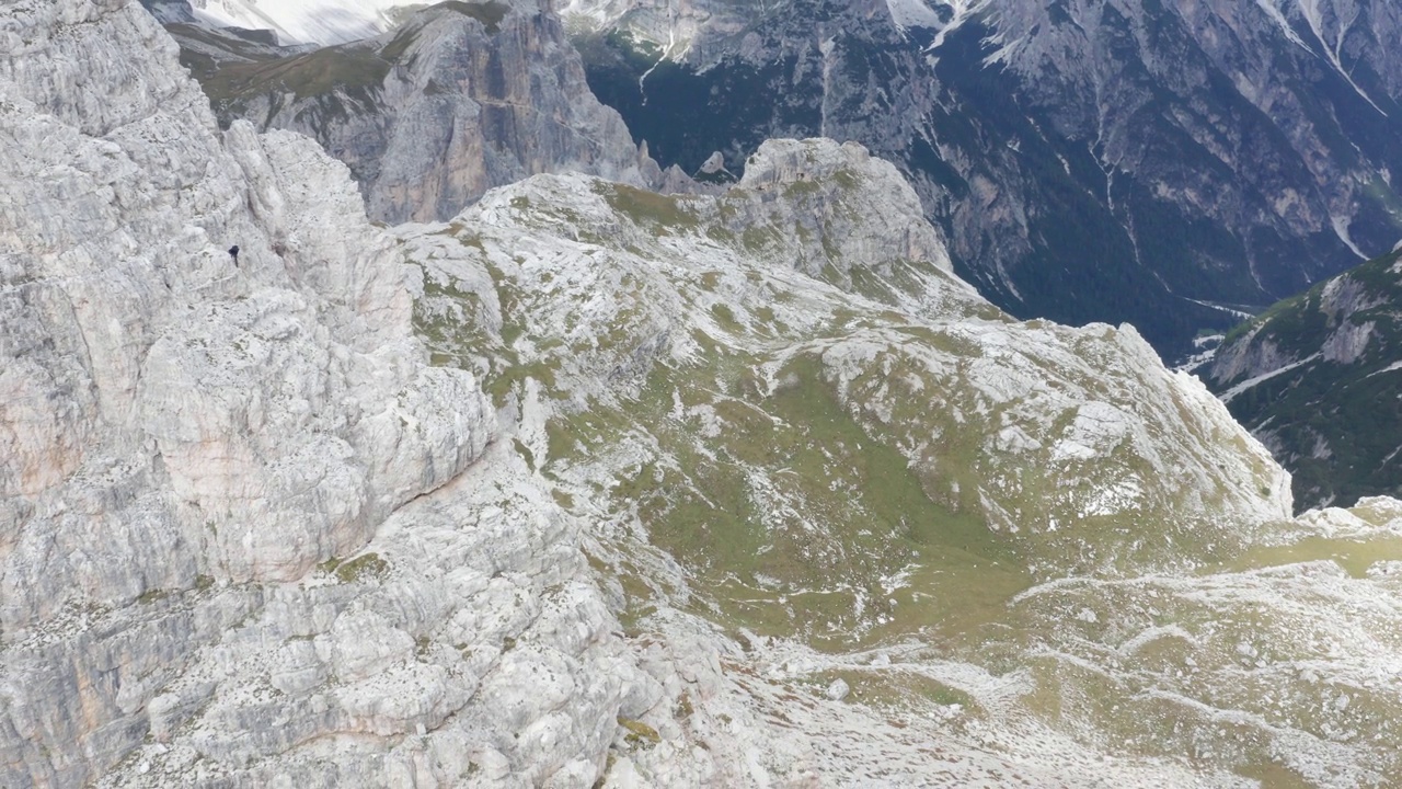 登山运动员从崎岖的托布林Torre di Toblin经ferrata下山;空中回拉视差视频素材