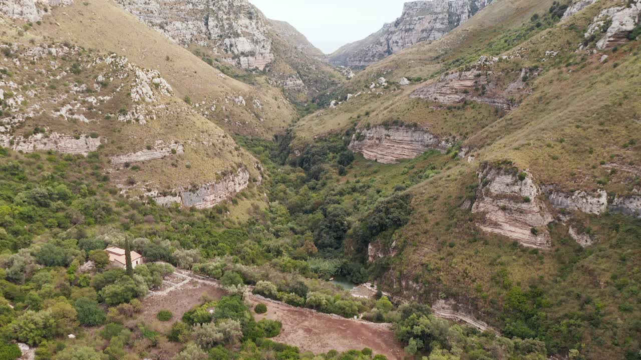 卡瓦格兰德del Cassibile峡谷自然保护区，溪流和郁郁葱葱的植被在阿沃拉，雪城，意大利。——空中视频素材