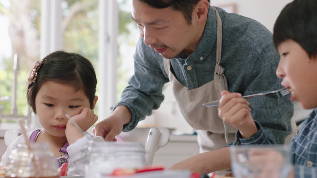 快乐的亚洲家庭吃煎饼早餐，孩子们享受健康的自制餐与父母在周末早上在厨房4k镜头视频素材