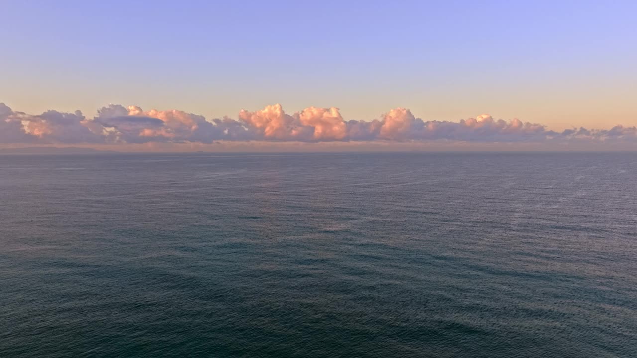 在加利福尼亚州赫莫萨海滩，空中拍摄的宁静海洋上空的蓬松云视频素材