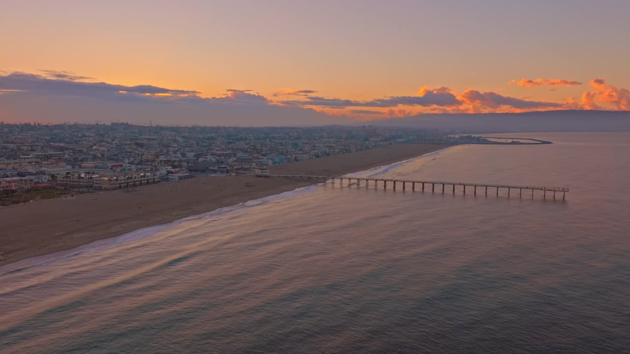 空中拍摄的一个空海滩和码头日落在赫莫萨海滩，CA视频素材