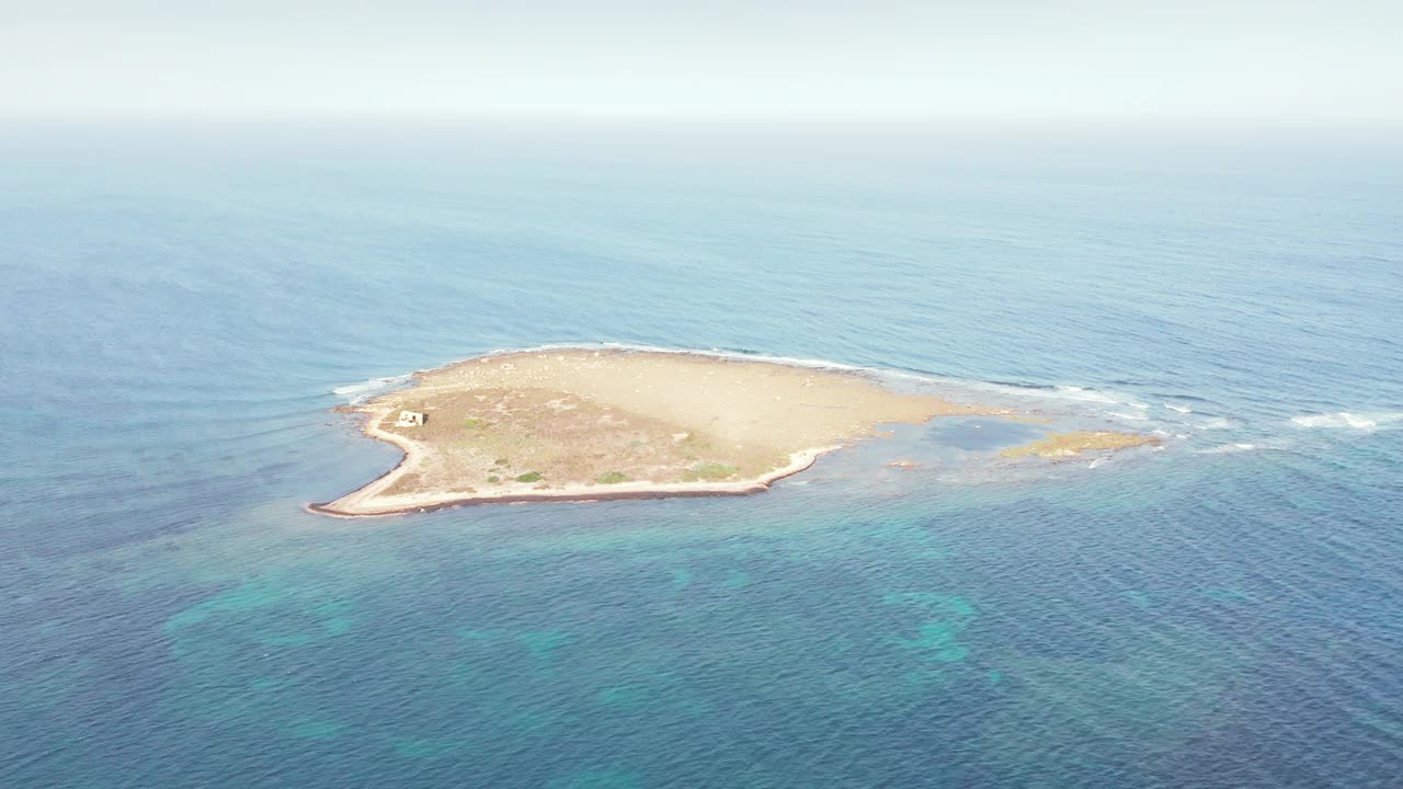 意大利锡拉丘兹的伊索拉·文迪卡里岛(Vendicari Island)，夏天被平静的蓝色海水包围。——空中视频素材