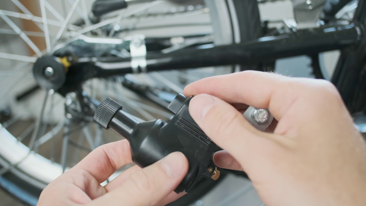 手握复古velo发电机。在自行车上安装自行车发电机。特写，在自行车店。POV，第一人称视角视频素材