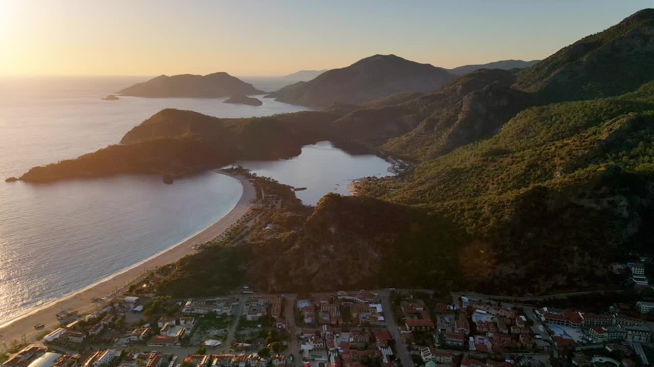 在日落的黄金时刻，飞越大海，美丽的沙滩和山脉。美丽的夏日风景。费特希耶，奥卢德尼兹海滩，土耳其视频素材