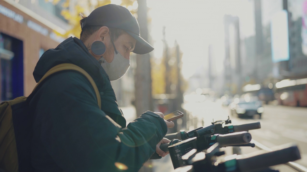 一名男性游客在韩国选择一辆自助租赁滑板车。视频素材