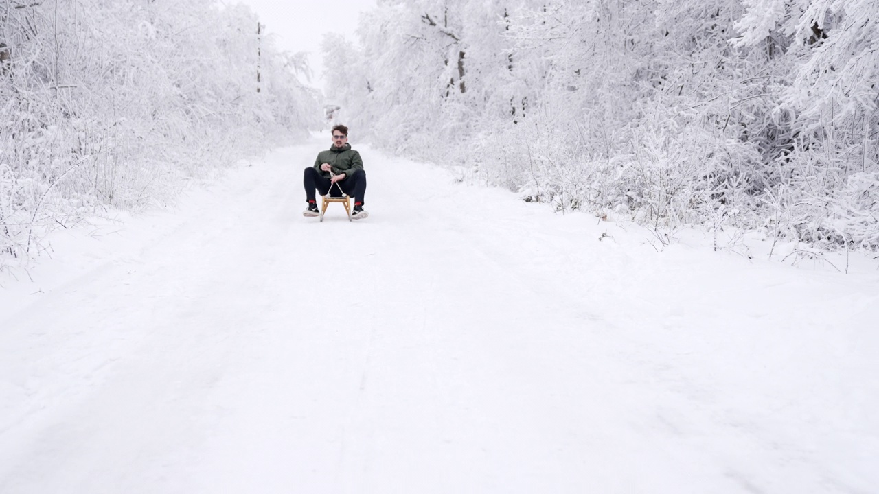 快乐的人在雪地上拉雪橇下山视频素材