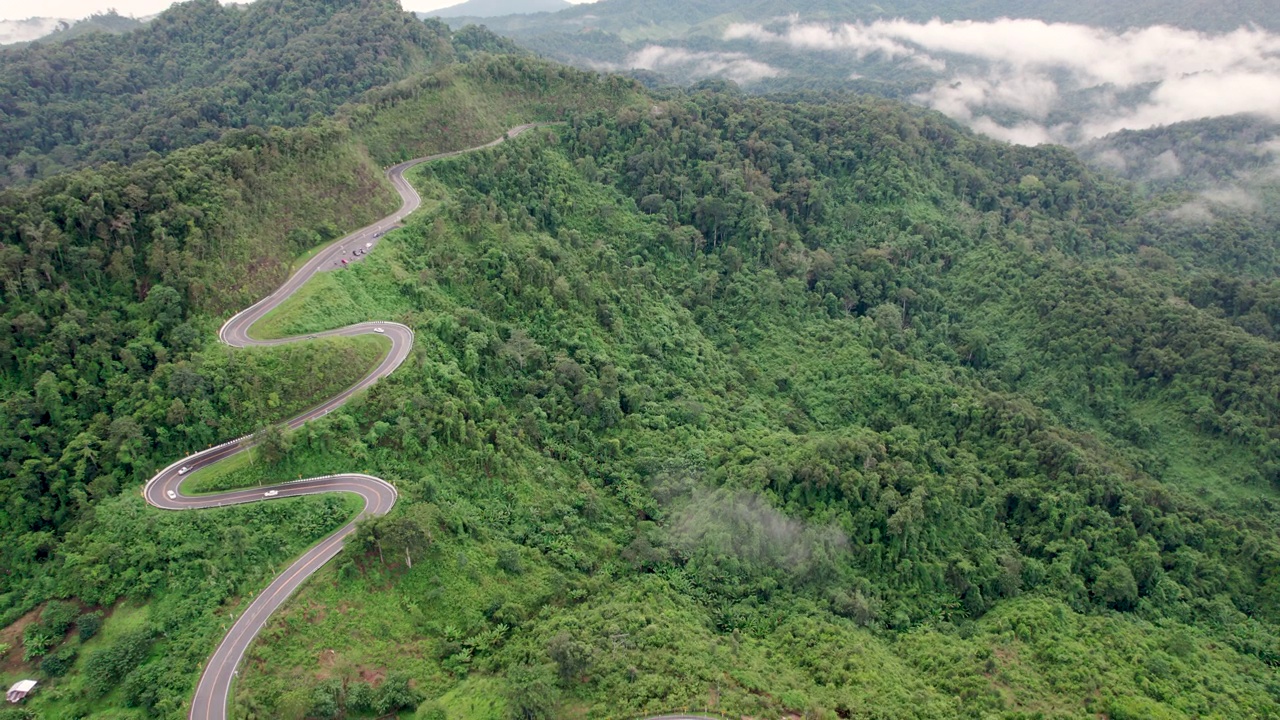 俯视乡村公路穿过绿色森林和山脉视频素材