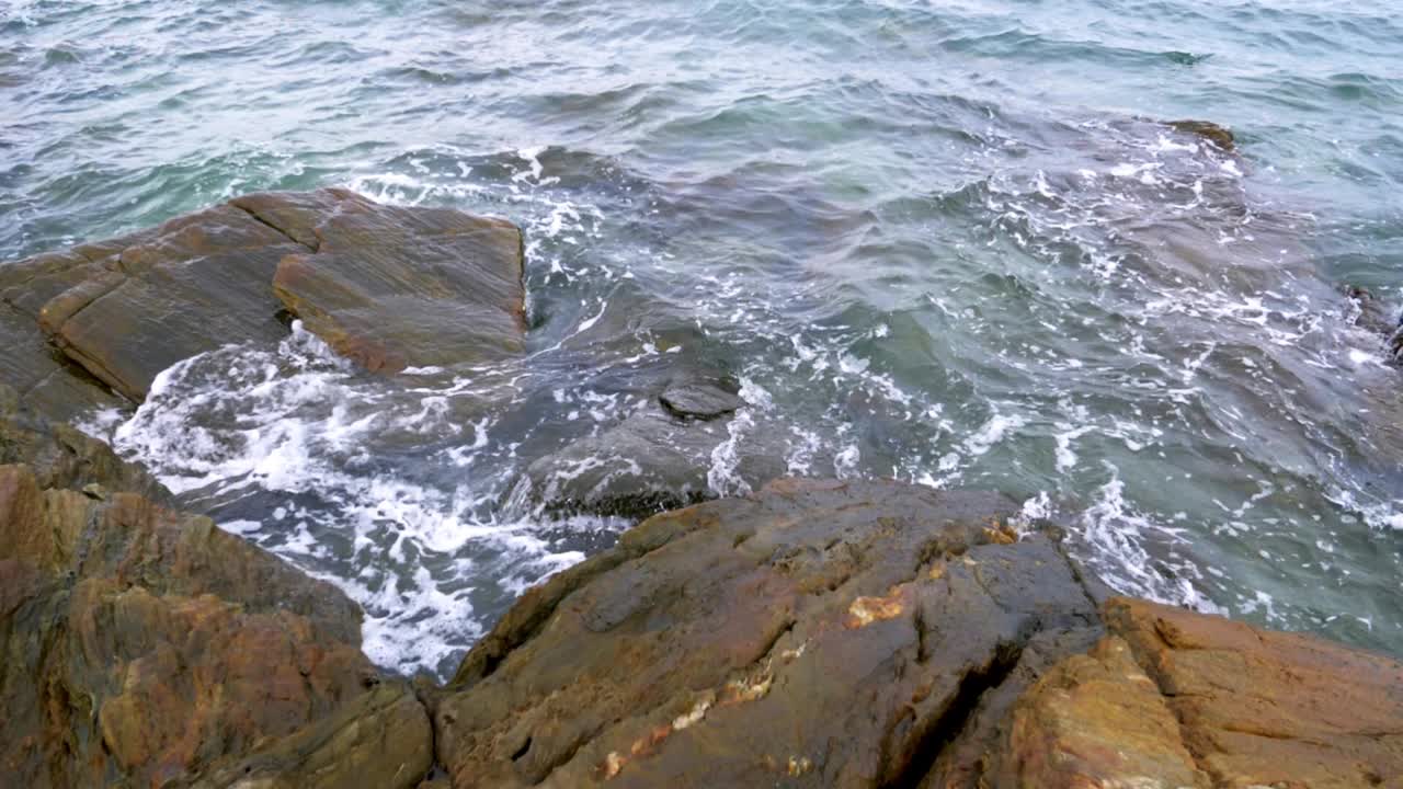 慢镜头的自然风景海浪海岸海滩与石头和岩石的暑假概念视频素材