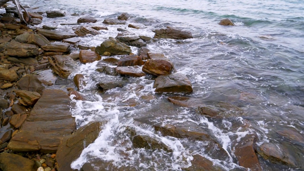 慢镜头的自然风景海浪海岸海滩与石头和岩石的暑假概念视频素材