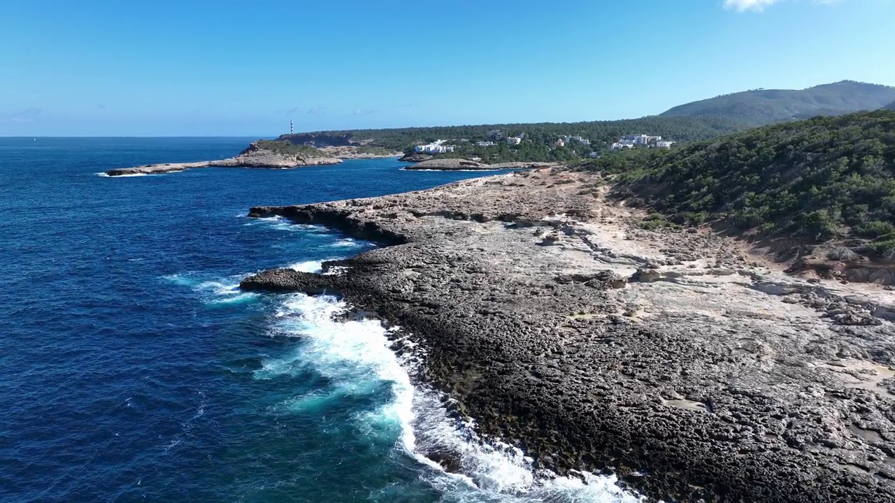 伊比沙岛北部的岩石地区。Portinatx海滩和地平线上的Moscarter灯塔。视频素材