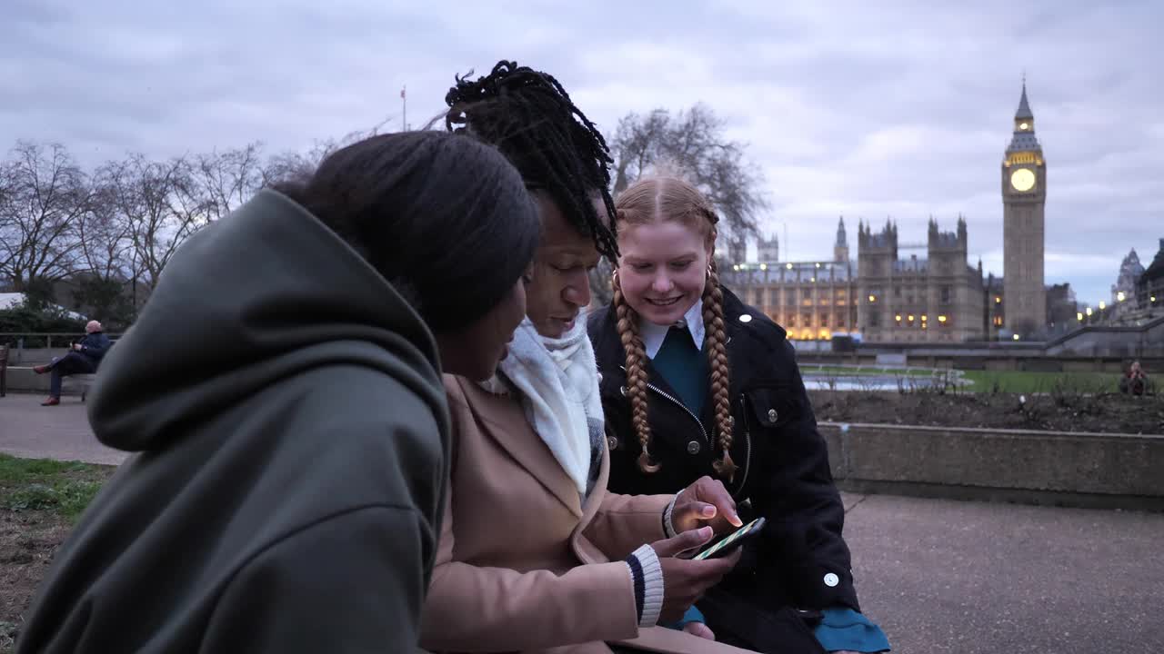 英国年轻人在冬天，在户外，使用智能手机和在线约会软件视频素材