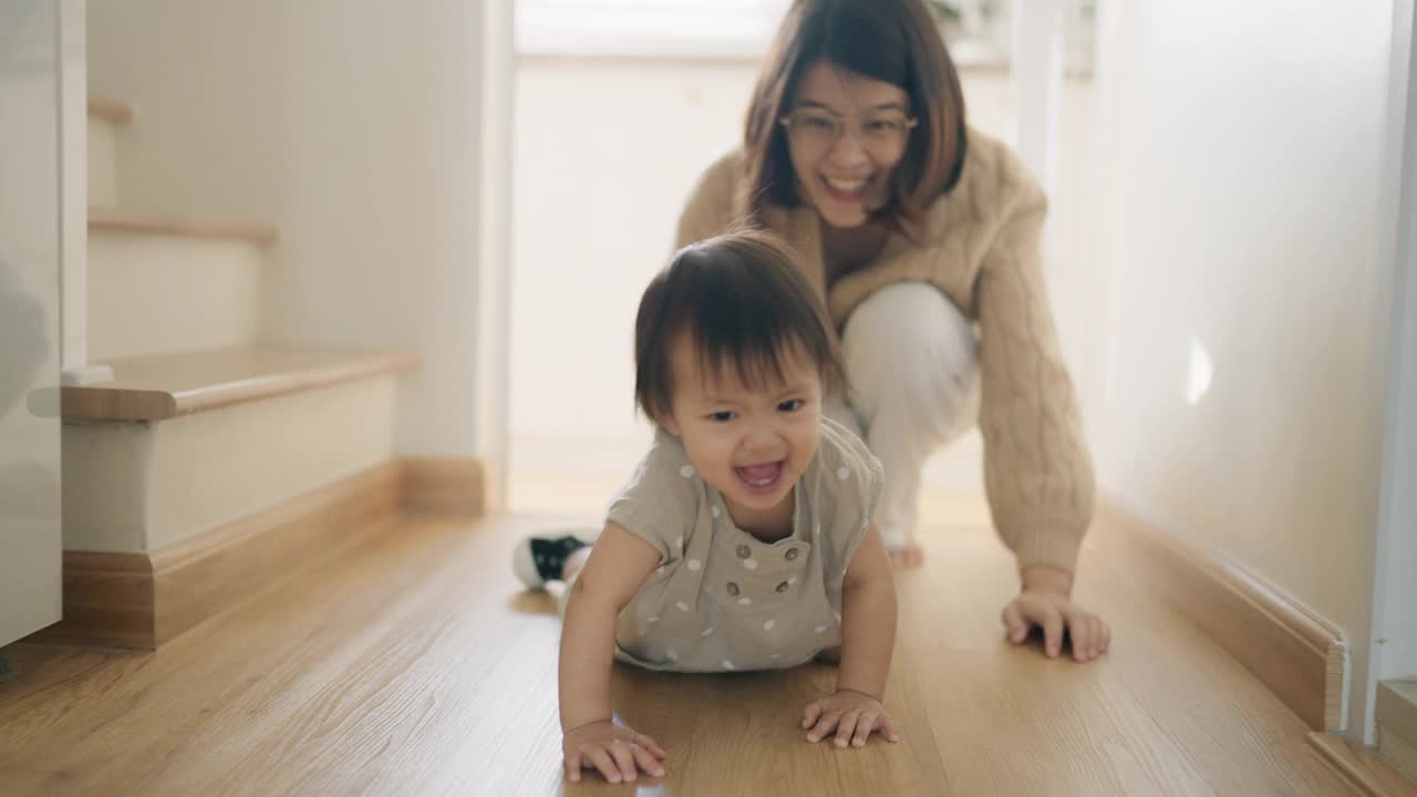 一个女婴在妈妈的搀扶下学走路。视频下载