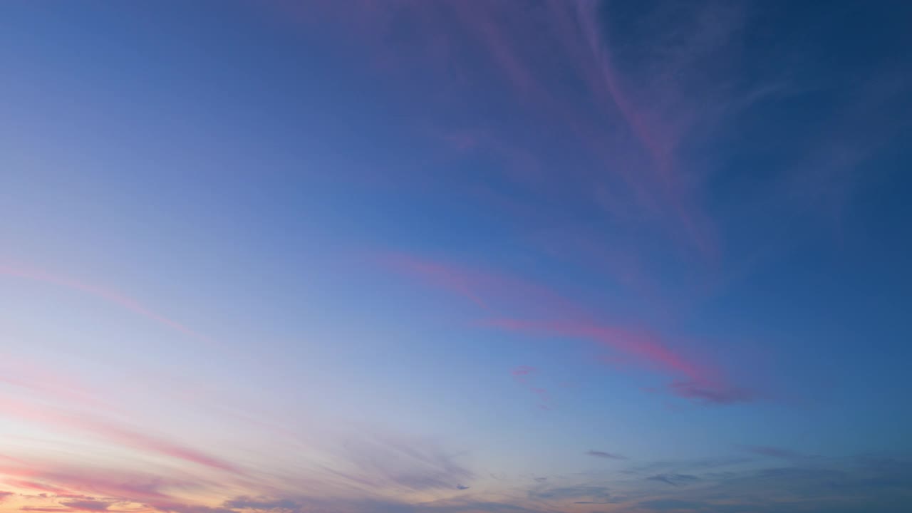 蓝色粉红色紫色日落背景。自然的夕阳白云飘在蓝天上。间隔拍摄。视频素材