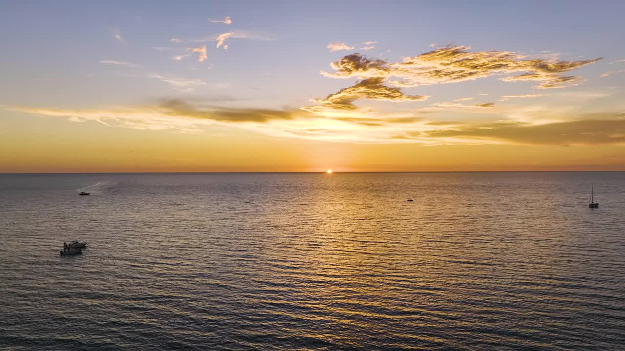 日落时漂浮在海浪上的白色游艇的鸟瞰图。海面摩托艇娱乐视频素材