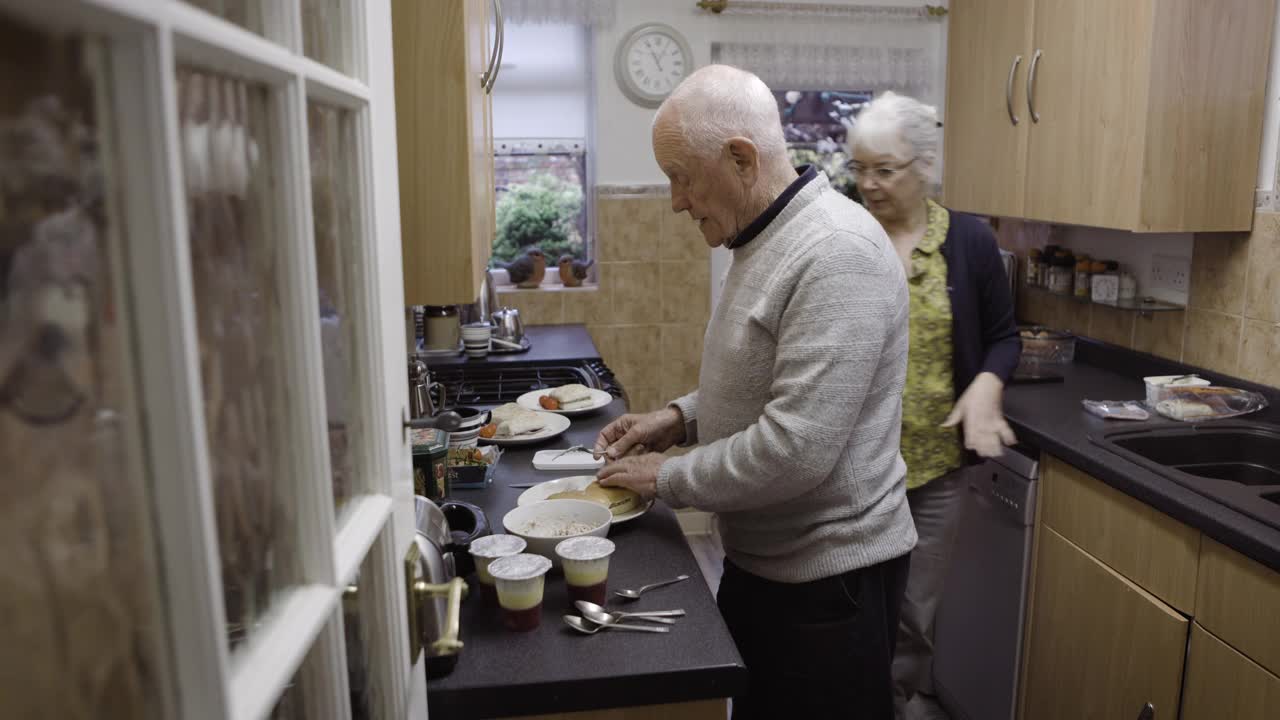 老两口做饭，退休与饮食搭配营养，健康生活方式与饮食搭配健康餐。婚姻中的帮助、爱与关怀，厨房中的老年男女，信任与退休人员视频素材