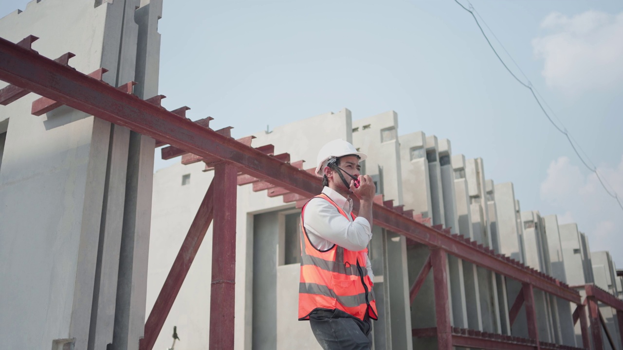 亚洲男性建筑工程师在工地使用对讲机检查工作。视频素材