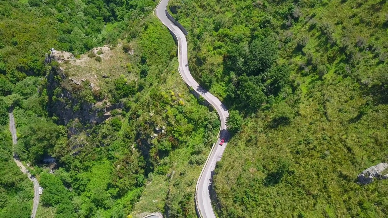 鸟瞰蜿蜒的蛇形道路，汽车行驶在弯弯曲曲的山路峡谷视频素材