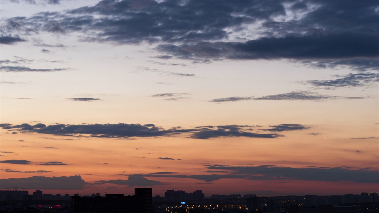 从白天到夜晚的时间推移。夜晚的城市上空，夕阳高照视频下载