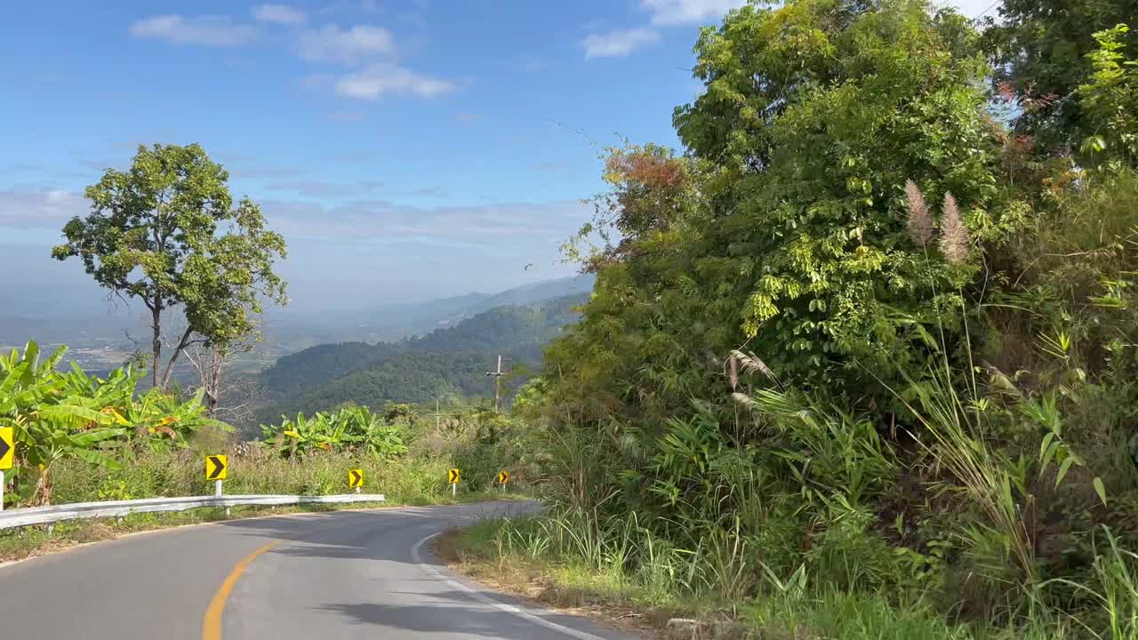 在有山的乡村道路上开车时的侧视图视频素材