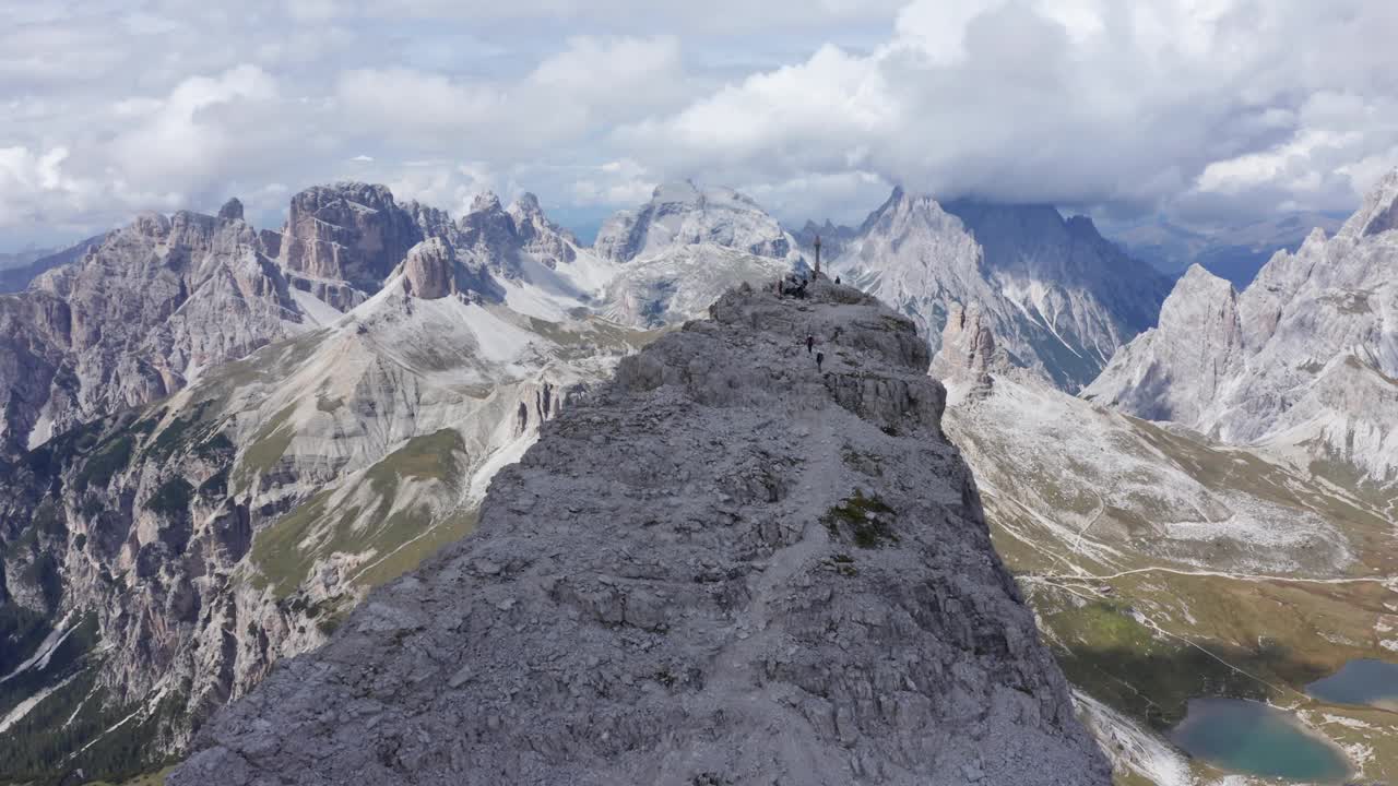 无人机拍摄的山峰在Tre Cime，峰顶交叉显示在下面的山谷里的Rifugio Locatelli。视频素材